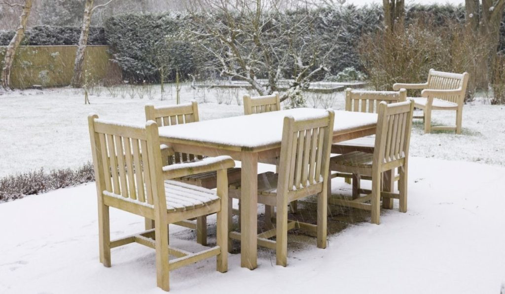Patio garden furniture in winter snow, UK