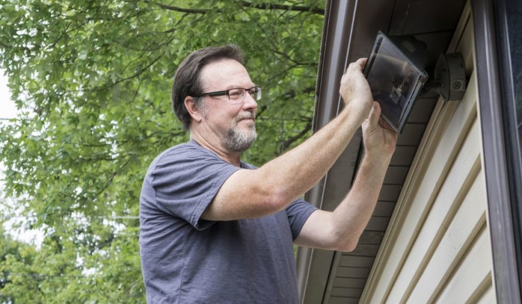 Electrician Changing Light Bulb In Exterior Light 