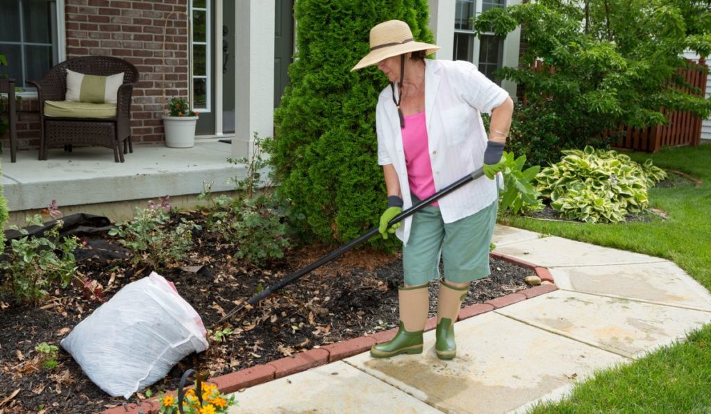 Older lady doing cleaning work in the yard