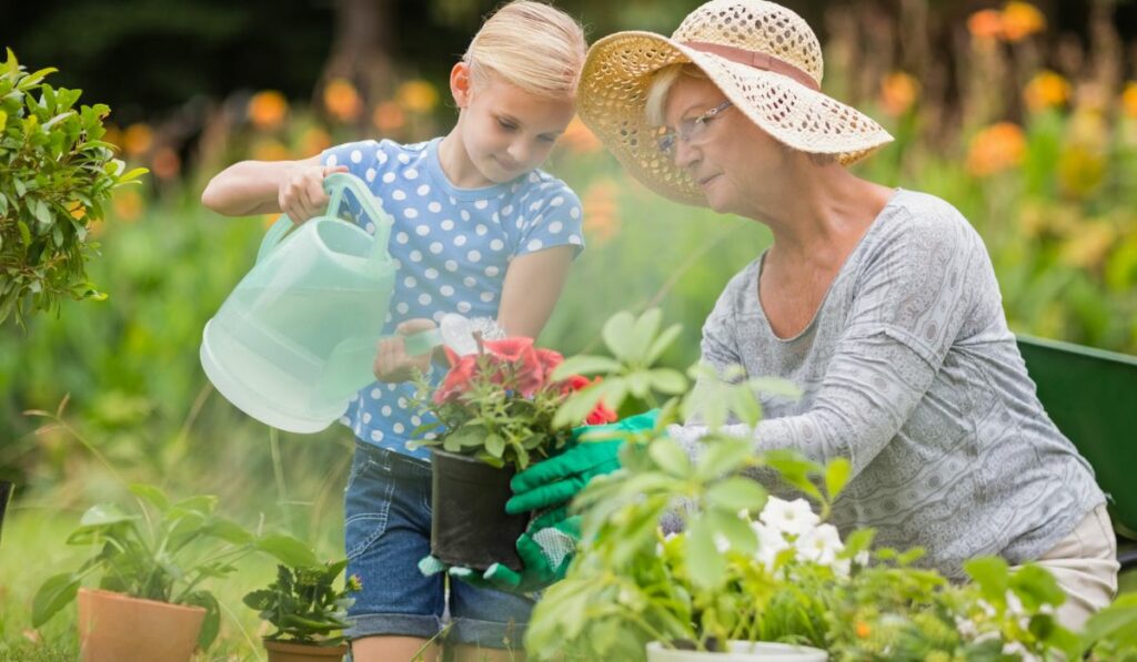 Happy grandmother with her granddaughter gardening