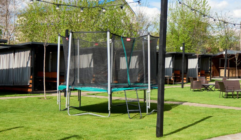 Kind on the playground jumping on the trampoline in the back yard